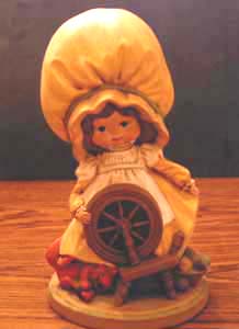 Ceramic Girl with Big Yellow Hat with Spinning Wheel Pic 1
